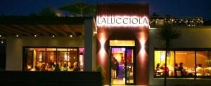 Facade du restaurant lalucciola à anglet debuit. On y voit la terrasse et la salle éclairées