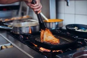 Escalope Romana dans sa poêle, en train d'être retournée