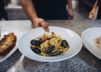 Le chef apporte une assiette de pâtes, Pappardelle au curry de Madras & Gambas
