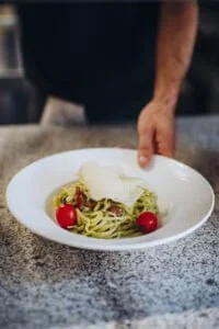 Une assiete de pâtes fraîches avec tomate, parmesan tranché