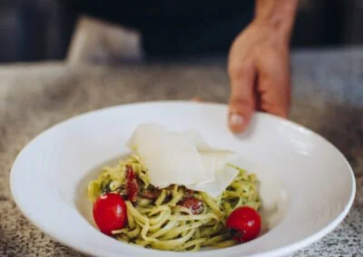 Une assiete de pâtes fraîches avec tomate, parmesan tranché
