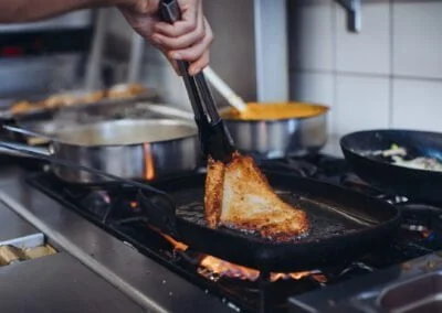 Escalope Romana dans sa poêle, en train d'être retournée