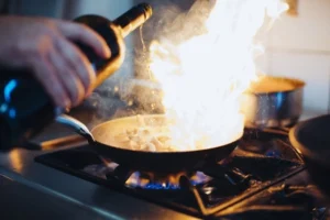 A Anglet, Photo des Cuisines du restaurant : une poêle où s'enflamme un alcool